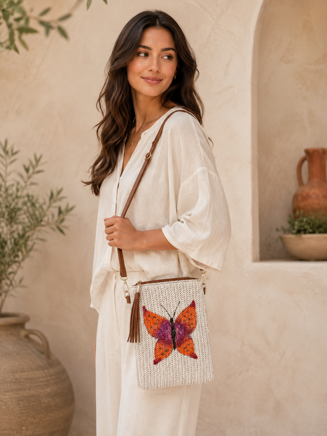Model wearing hand-painted Butterfly Single straw crossbody bag outdoors